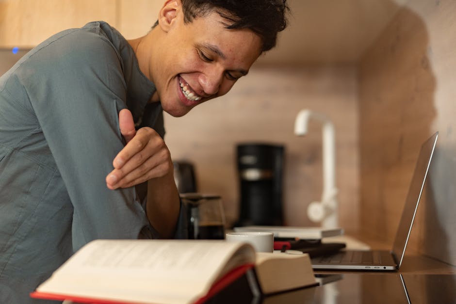 Image depicting a person laughing while reading a book about personal finance